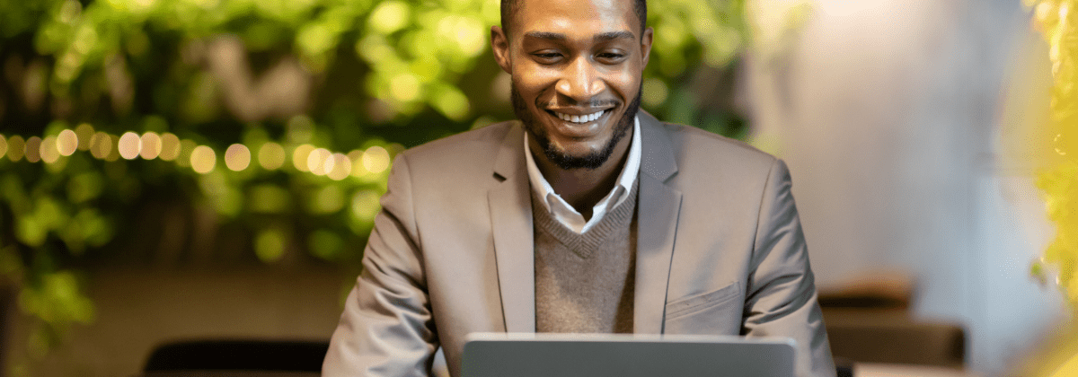 Attractive man smiling whilst using laptop